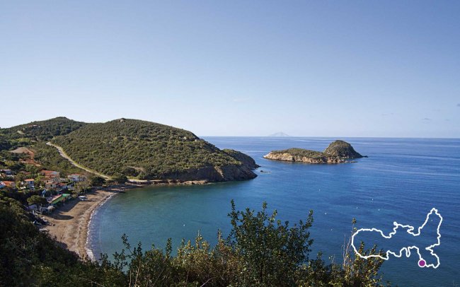 Baia tranquilla con spiagge e colline verdi.