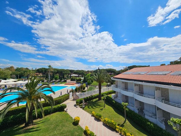 Vista su edifici, giardino e piscina.