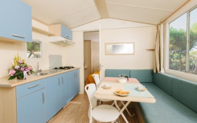 Cucina mobile con tavolo, divano e fiori.