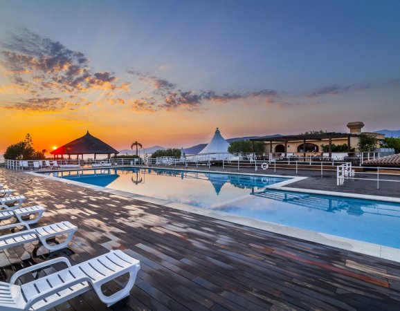 Piscina e lettini al tramonto.