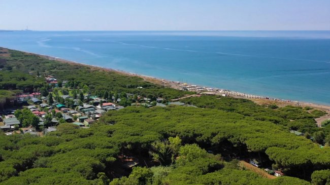 Vista aerea di campeggio verde e costa blu.