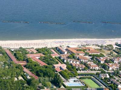 Veduta aerea di una spiaggia con stabilimenti balneari, strutture turistiche e campi da gioco.