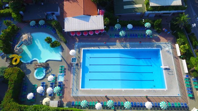 Vista dall'alto di piscine con lettini e ombrelloni.