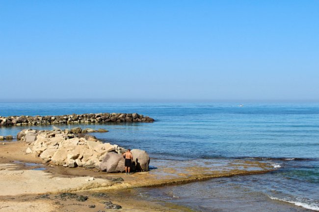 Spiaggia con scogli e cielo blu.