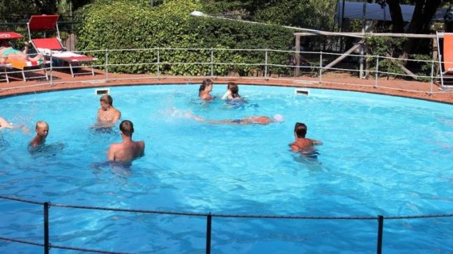Persone che nuotano in una piscina rotonda.