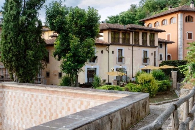 Edificio storico con alberi e terrazze.