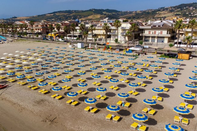 Spiaggia con ombrelloni blu e gialli.
