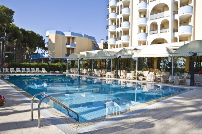 Piscina esterna con edificio dietro.