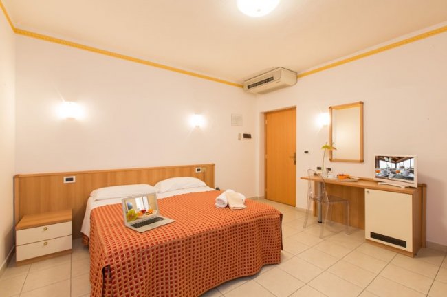 Camera d'hotel con letto matrimoniale e scrivania.