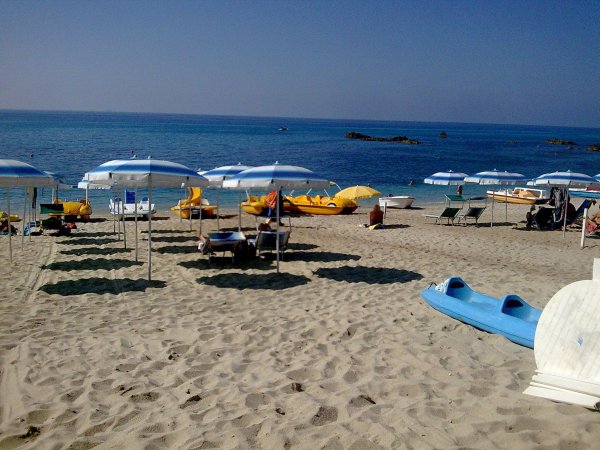Spiaggia con ombrelloni e pedalò.