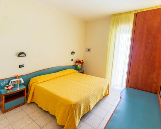 Camera con letto matrimoniale giallo.