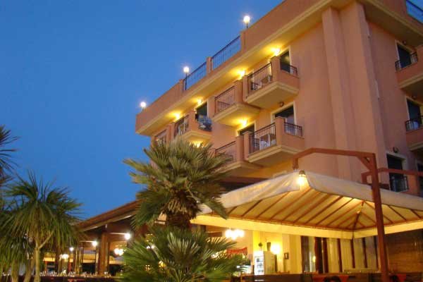 Edificio con balconi e area ristorante illuminata.