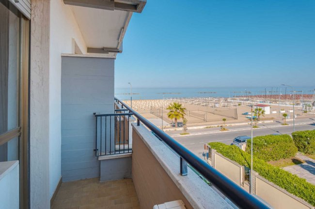 Balcone che si affaccia sul mare con spiaggia.