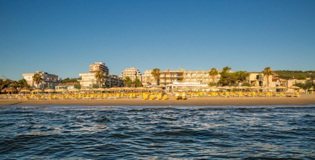 Spiaggia con ombrelloni gialli fronte mare.