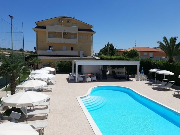 Piscina vista dall'alto accanto a un edificio giallo.