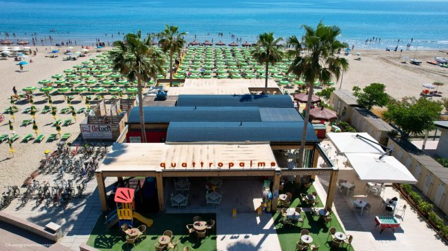 Spiaggia con ombrelloni e bar.