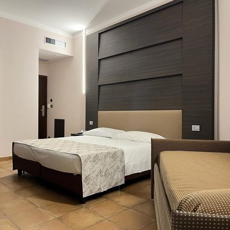 Camera d'albergo con letto matrimoniale e arredo semplice.