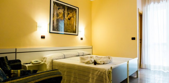 Camera con letto matrimoniale e luci soffuse.