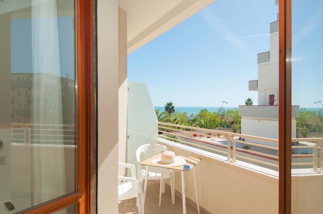 Balcone con vista mare e tavolino in plastica.