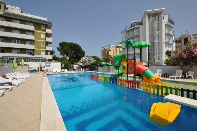 Piscina con giochi acquatici per bambini vicino a edifici.