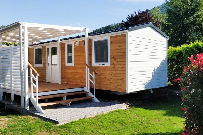 Casa mobile con veranda in giardino soleggiato.