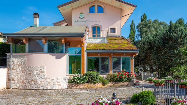 Edificio moderno con tetto verde e giardino fiorito.