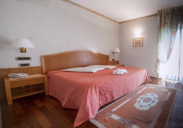 Camera da letto con letto matrimoniale e luci soffuse.