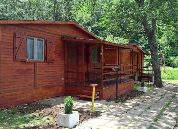 Una casetta di legno con veranda e finestre chiuse.
