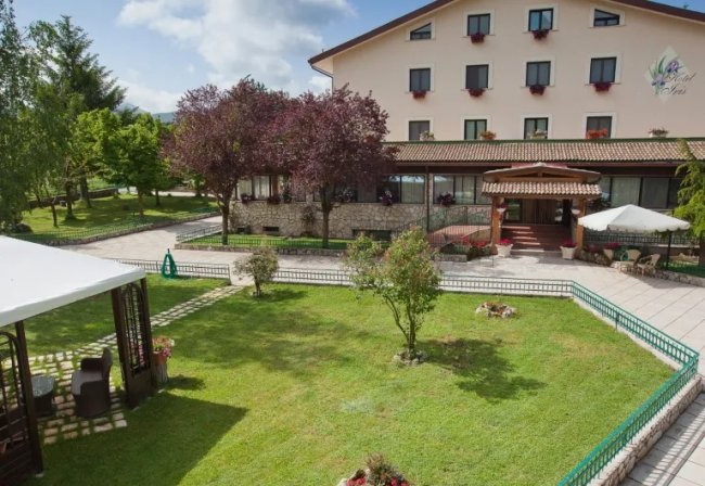 Hotel con giardino ben curato e terrazza.