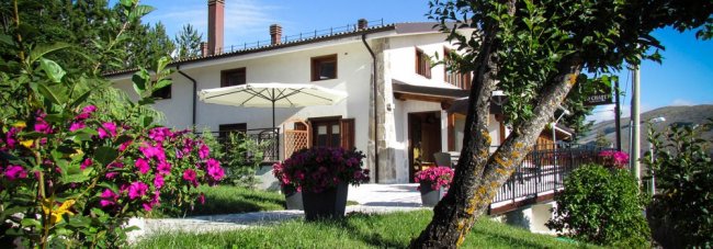 Casa bianca con fiori colorati in giardino.
