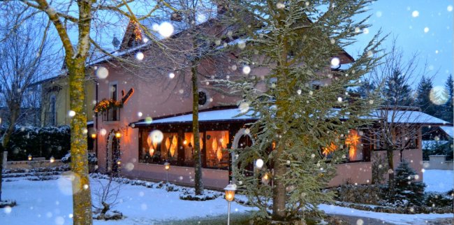 Casa innevata illuminata di sera.