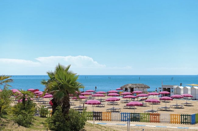 Spiaggia con ombrelloni rosa.