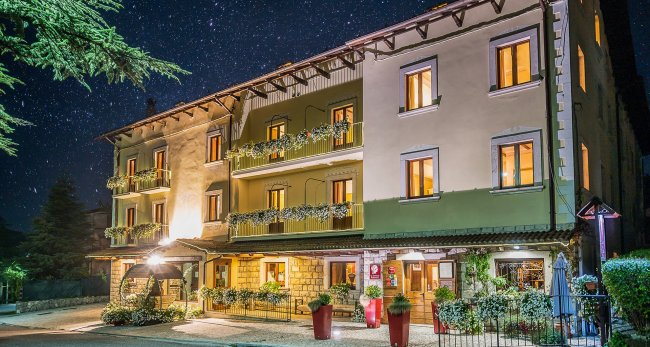 Hotel illuminato di notte con stelle sullo sfondo.