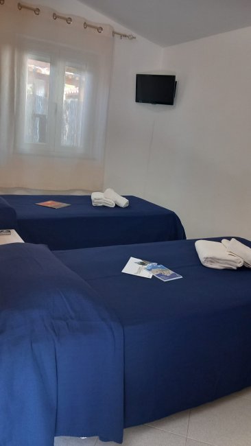Due letti singoli con copriletto blu.