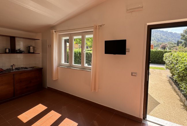 Cucina luminosa con finestra e porta aperta.