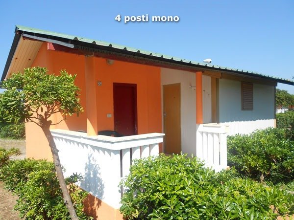 Casa arancione e bianca con giardino.