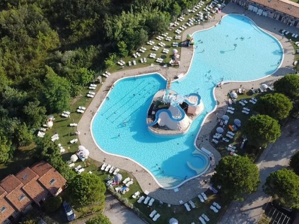 Grande piscina a forma di isola con lettini