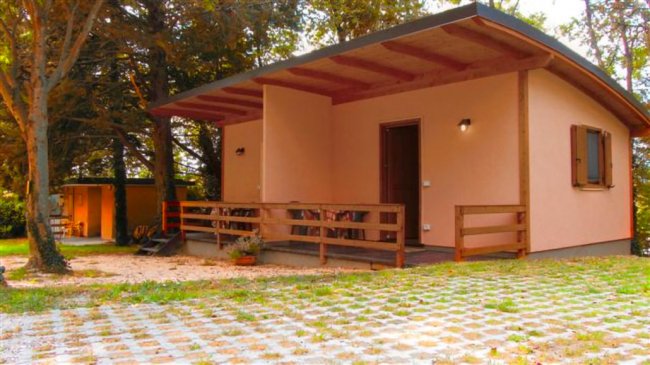 Un bungalow con patio in un'area alberata.