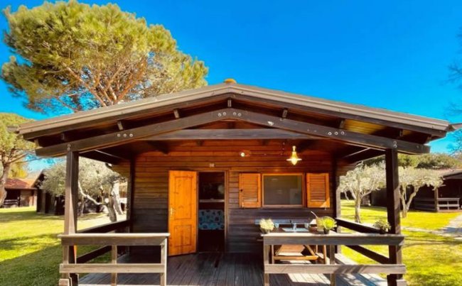 Bungalow in legno con portico, in un giardino.