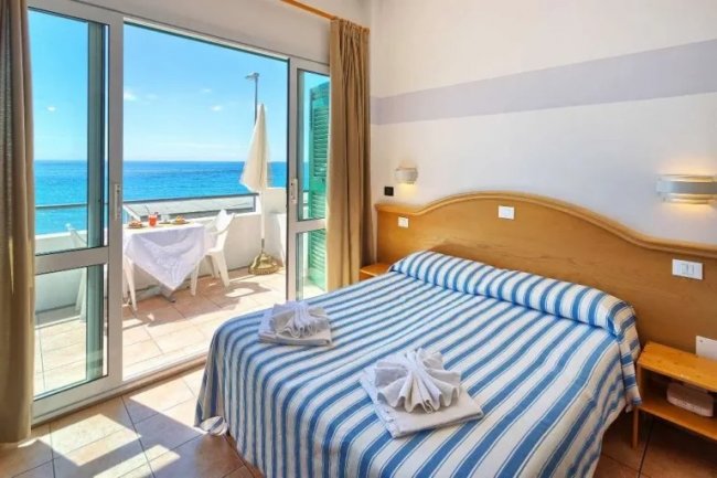 Camera con letto matrimoniale e balcone sul mare.