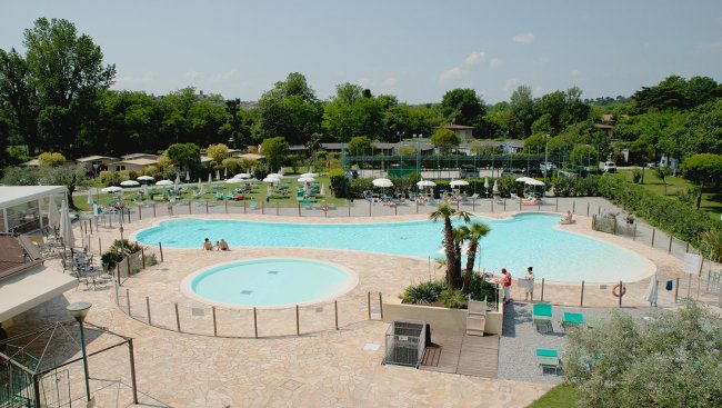 Piscina all'aperto con sdraio e ombrelloni.
