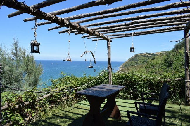 Pergolato con tavolo e vista sul mare.