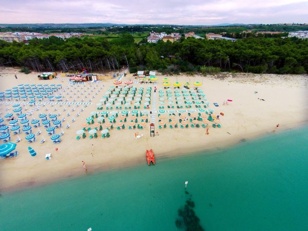 Spiaggia con ombrelloni colorati e acqua turchese.