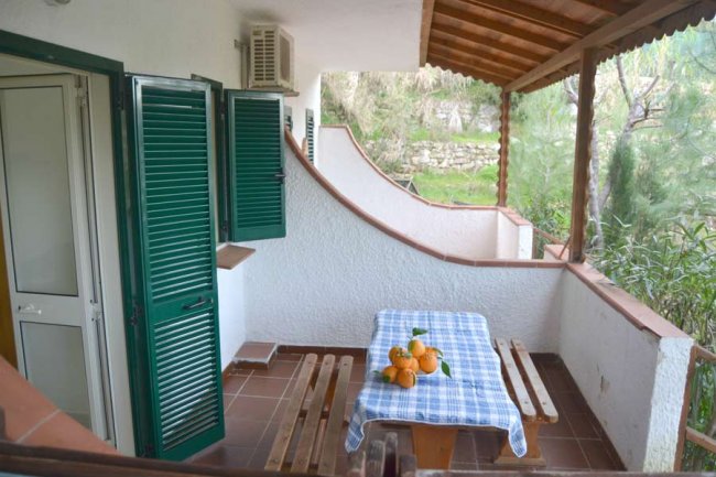 Veranda con tavolo, sedie e arance.