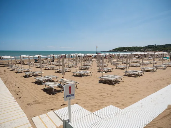 Spiaggia con lettini e ombrelloni.