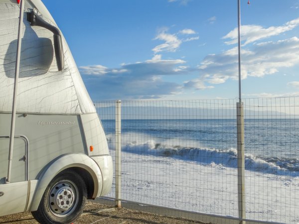 Camper bianco vicino al mare.