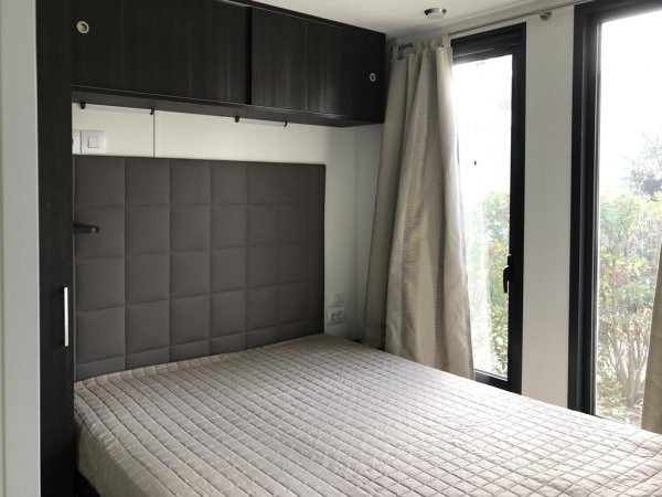 Camera da letto con letto matrimoniale e armadi scuri.