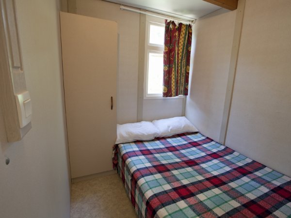 Camera con letto matrimoniale e copriletto a quadri.