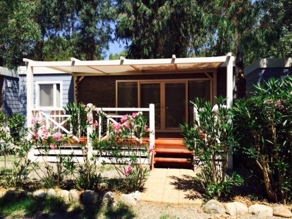 Bungalow con veranda e piante intorno.