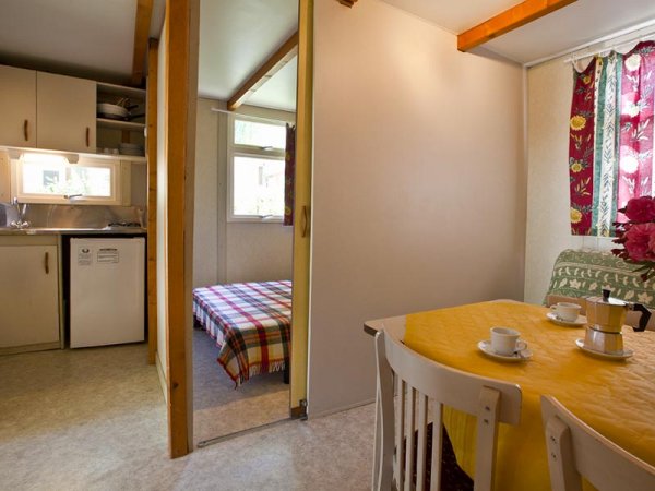 Cucina e zona pranzo con tavolo giallo.